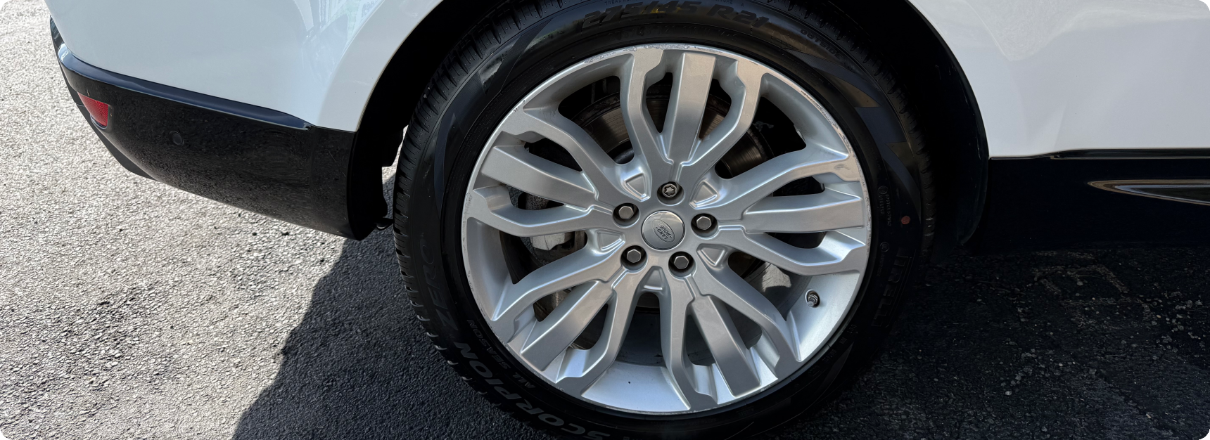 Close-up silver alloy wheel on white SUV