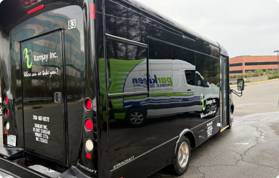 Black shuttle bus with reflected white service van