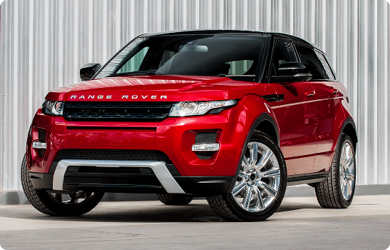 Red Range Rover Evoque parked by metal wall
